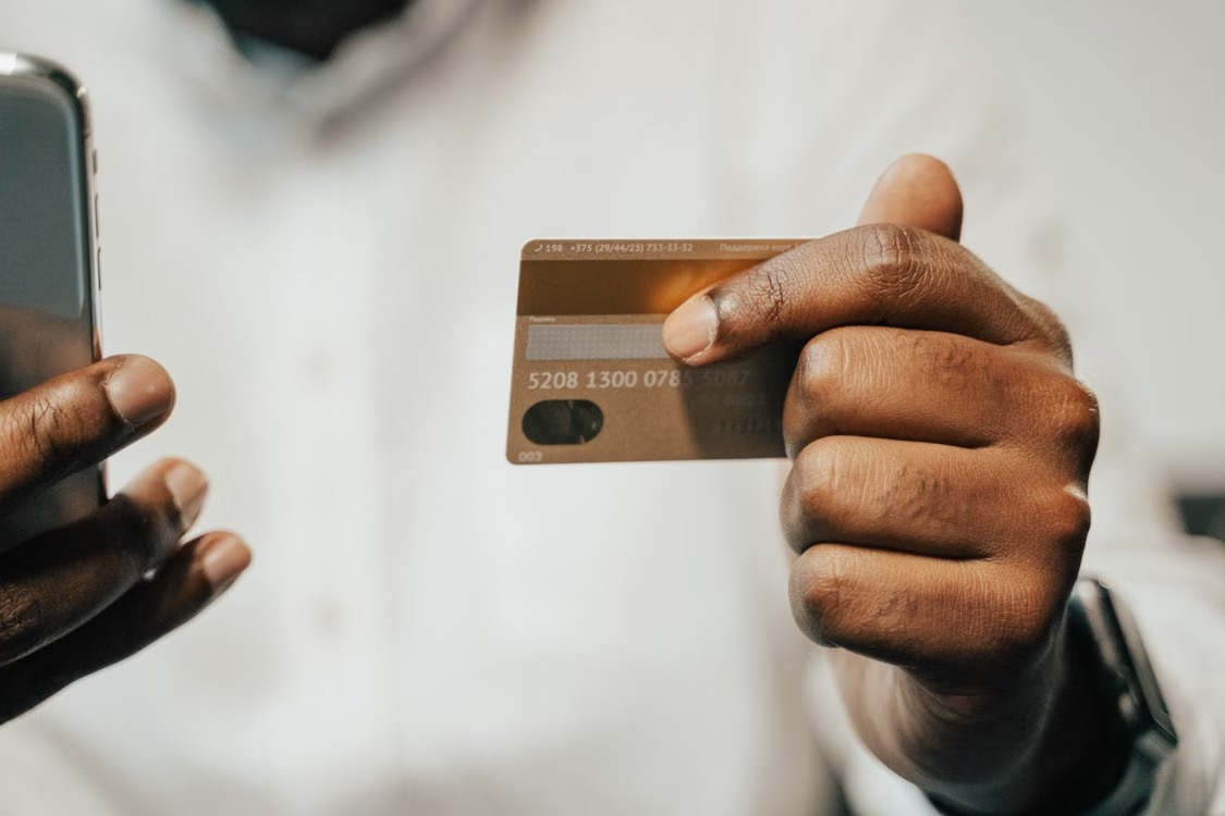 Hands holding a smartphone and a payment card.